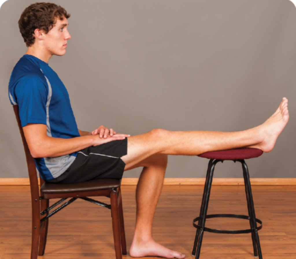 Image shows man with his knee extended showing range of motion extension on a chair